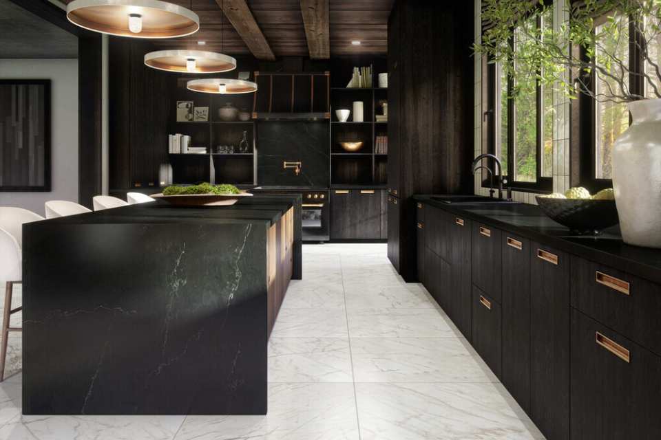 white marble floor in black kitchen with brass accents, wood beams and greenery